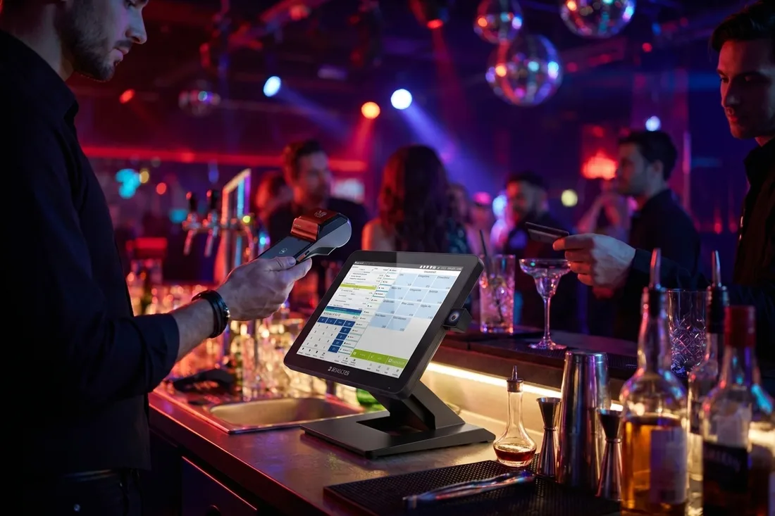 Barkeeper mixt Cocktails im Nachtclub, beleuchtete Touch-Kasse an der Bar